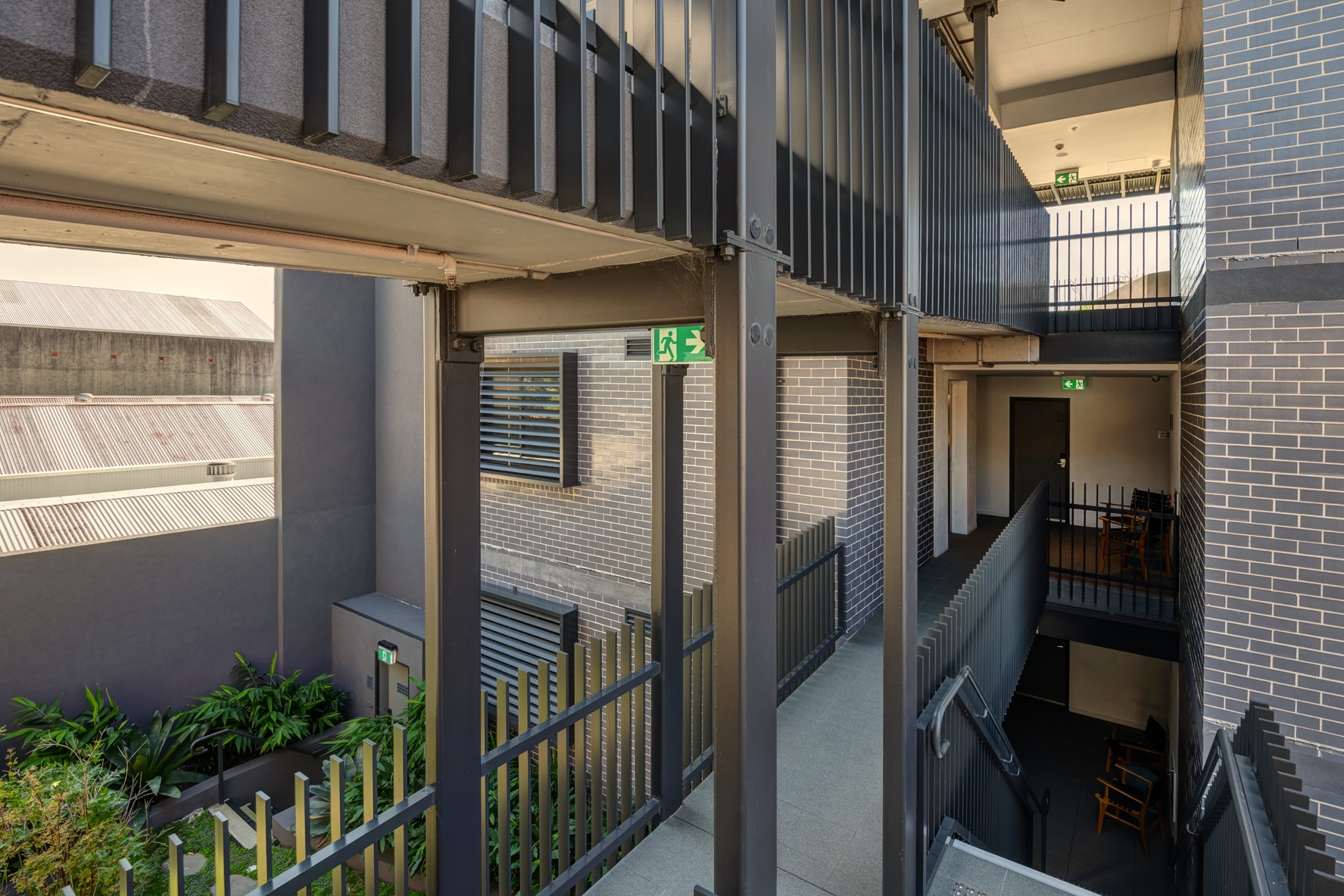 Annandale boarding house internal corridor with brick walls and metal railings